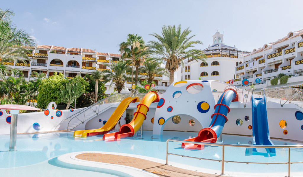 Kinderbereich mit Wasserrutschen und Palmen in einem Hotel in Teneriffa.