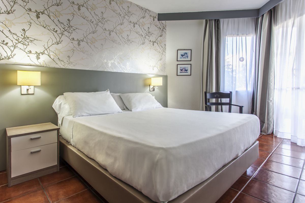 Doppelzimmer mit Bett, Nachttisch und Lampe in einem Hotel in Teneriffa.