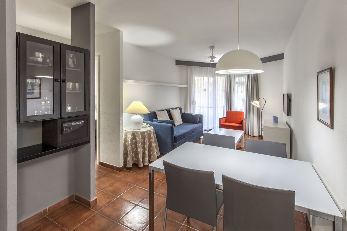 Wohnzimmer mit Sofa, Tisch, Stühlen und Lampe in einem Apartment in Tenerife.