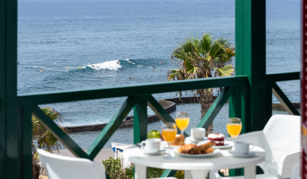 Blick auf das Meer in Teneriffa mit Tisch, Frühstück und Orangensaft im Vordergrund.