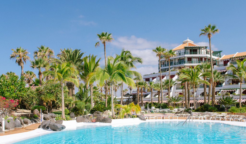 Hotel mit Palmen und Pool in Costa Adeje, Teneriffa.