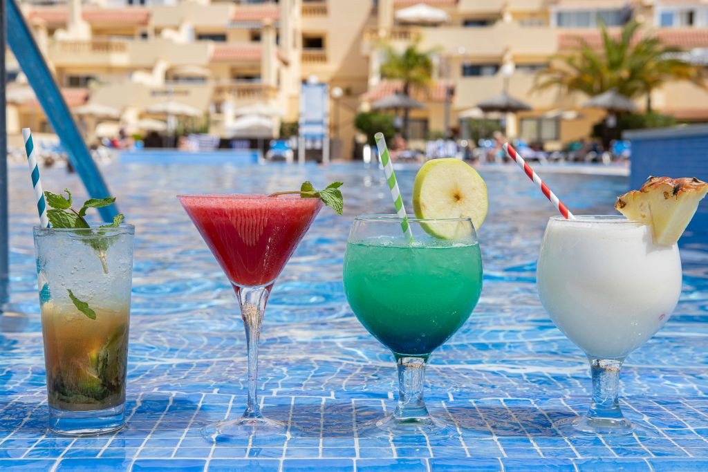 Vier Cocktails auf einem Poolrand in einem Hotel in Tenerife.
