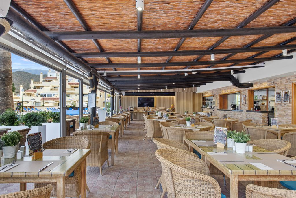 Überdachte Terrasse mit Korbmöbeln und Tischdekoration in einem Restaurant in Tenerife.
