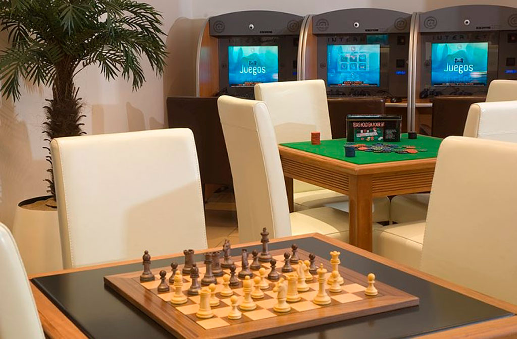 Schachspiel auf Tisch im Spielzimmer, im Hintergrund Spielautomaten mit Juegos in Teneriffa.