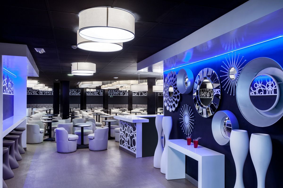 Moderne Bar mit weißen Stühlen und dekorativen Spiegeln in Tenerife.