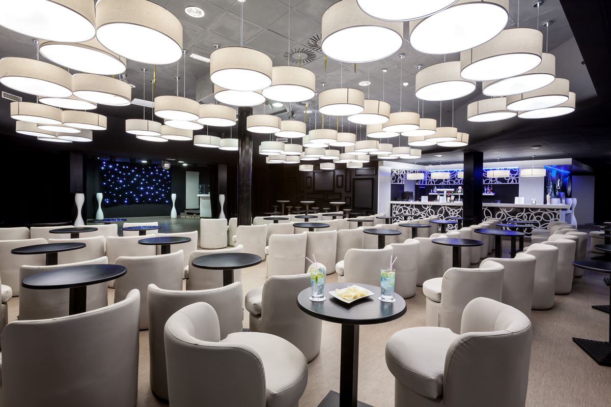 Moderne Lounge mit weißen Sesseln und Tischen in Adeje, Teneriffa.