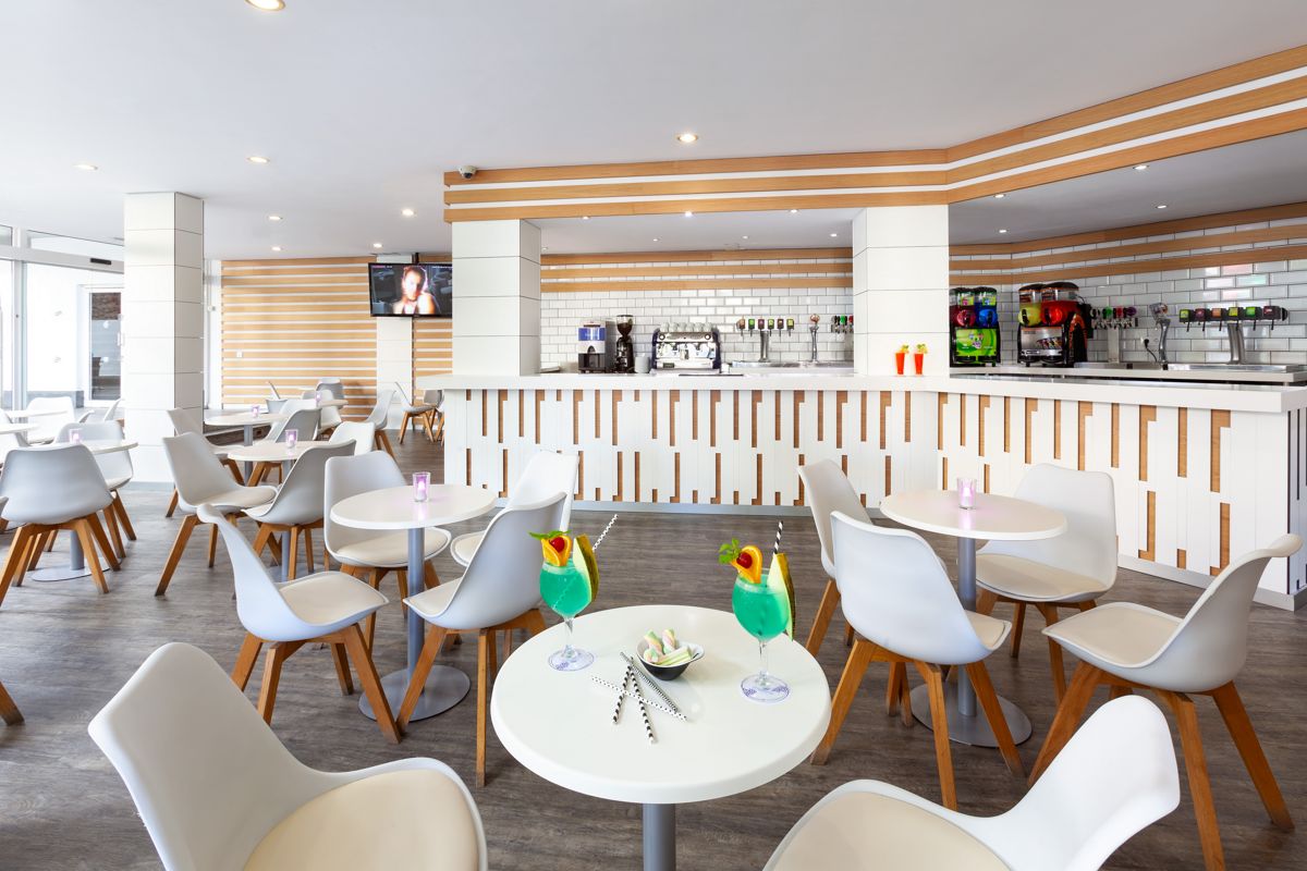 Moderne Cafeteria mit weißen Tischen und Stühlen in Tenerife.