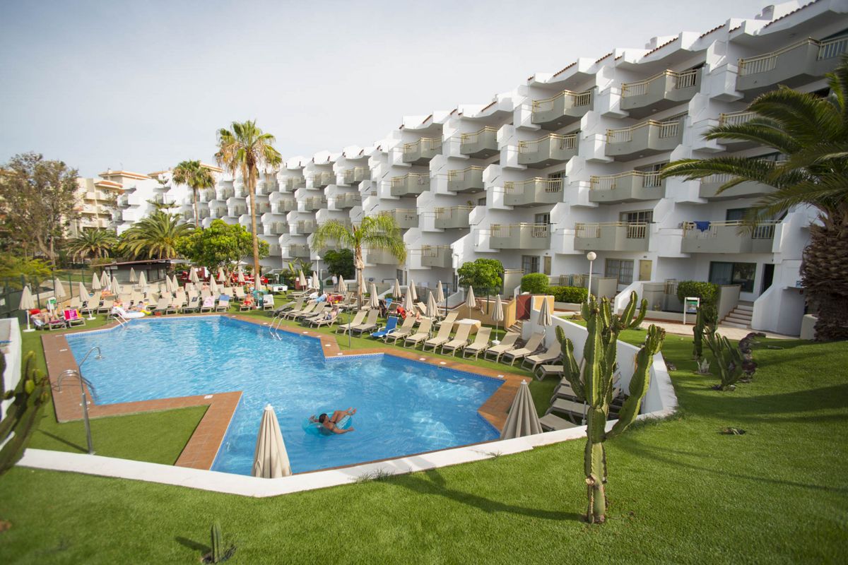 Außenpool mit Liegestühlen und Apartments im Hintergrund in Costa Adeje, Teneriffa.