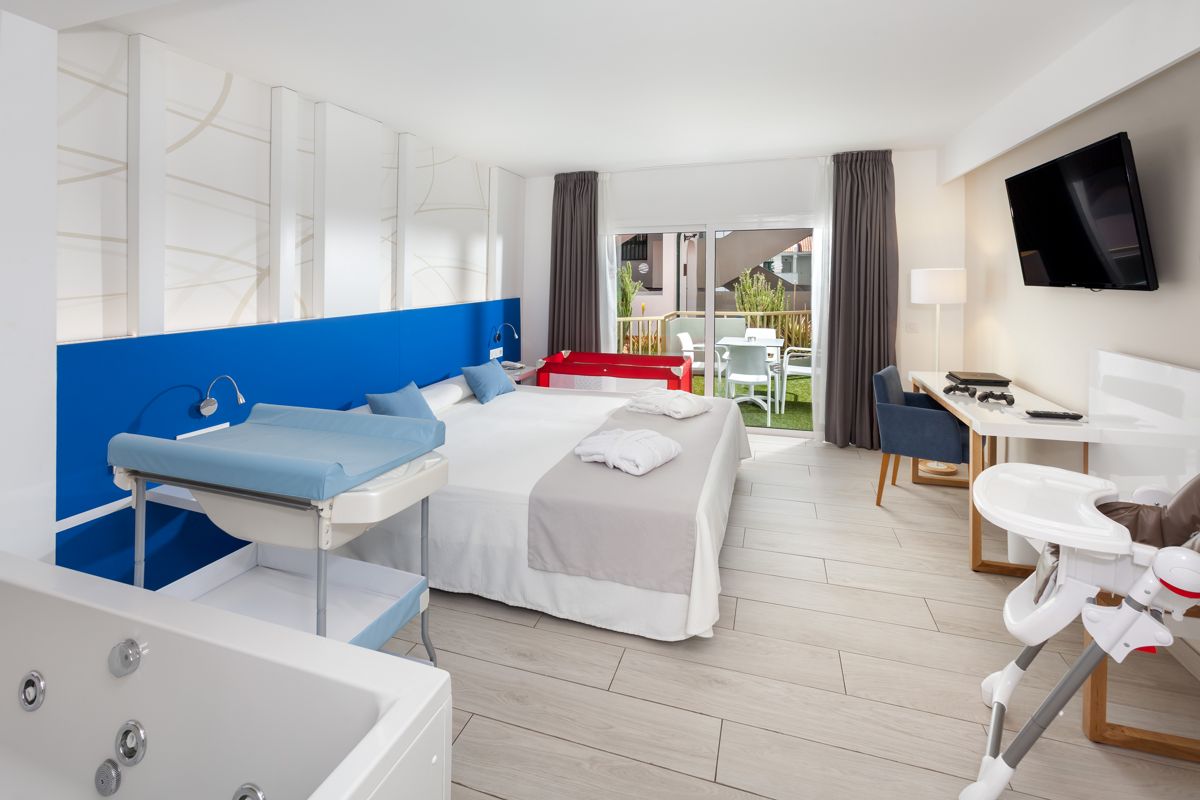 Modernes Hotelzimmer mit Babybett, Wickeltisch und Balkon in Puerto de la Cruz, Teneriffa.