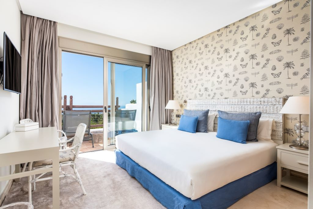 Schlafzimmer mit Doppelbett, Schreibtisch und Balkon mit Meerblick in Teneriffa.