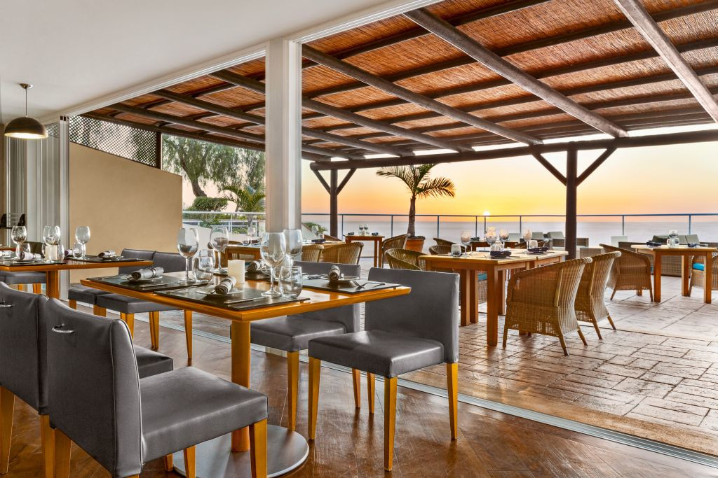 Restaurantterrasse mit gedeckten Tischen und Sonnenuntergang in Teneriffa.