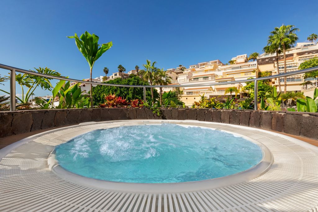 Whirlpool auf einer Terrasse mit Blick auf Teneriffa und umliegende Gebäude.