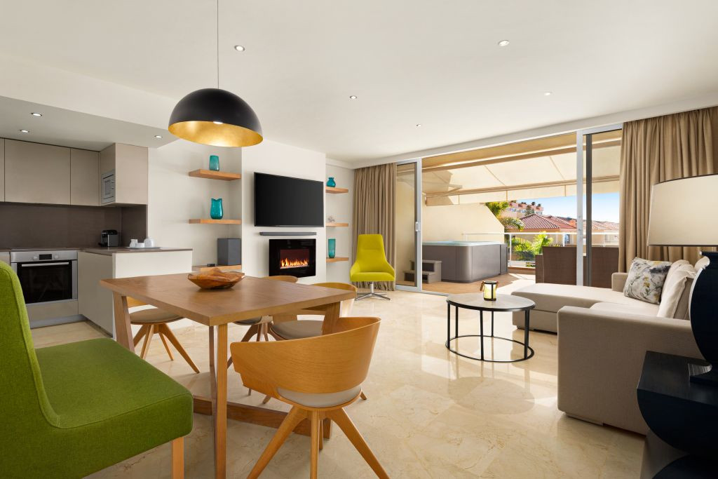Modernes Wohnzimmer mit Küche und Zugang zur Terrasse in einem Apartment in Teneriffa.