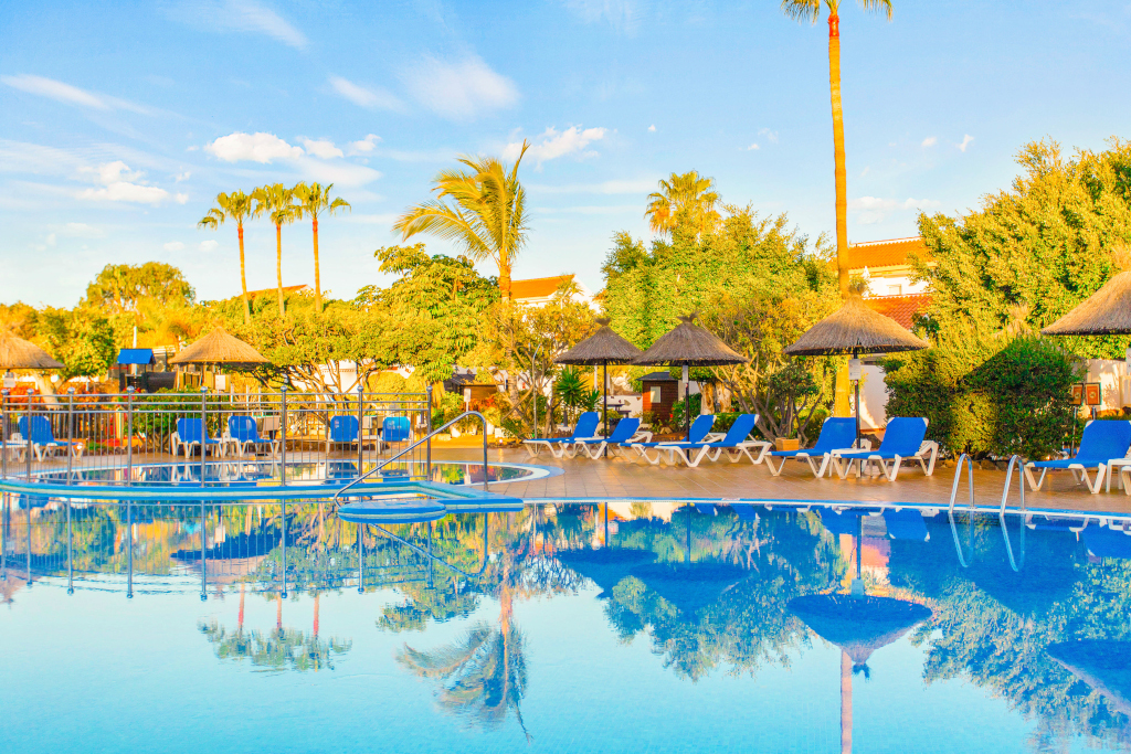 Pool mit Liegestühlen und Sonnenschirmen in einem Hotel in Tenerife.