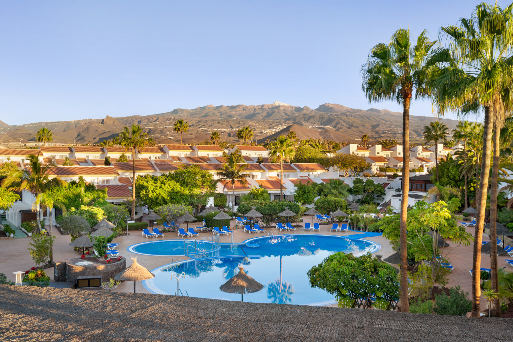 Hotelanlage mit Pool und Bergen im Hintergrund in Costa Adeje, Teneriffa.