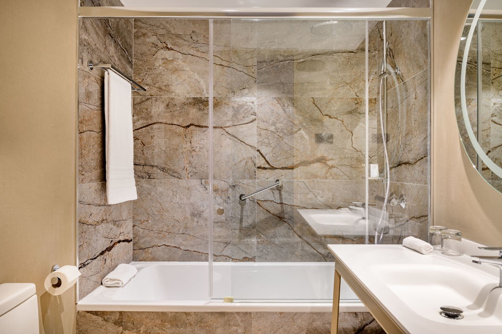 Badezimmer mit Marmorduschenwand, Badehandtuch und Waschbecken in Tenerife.