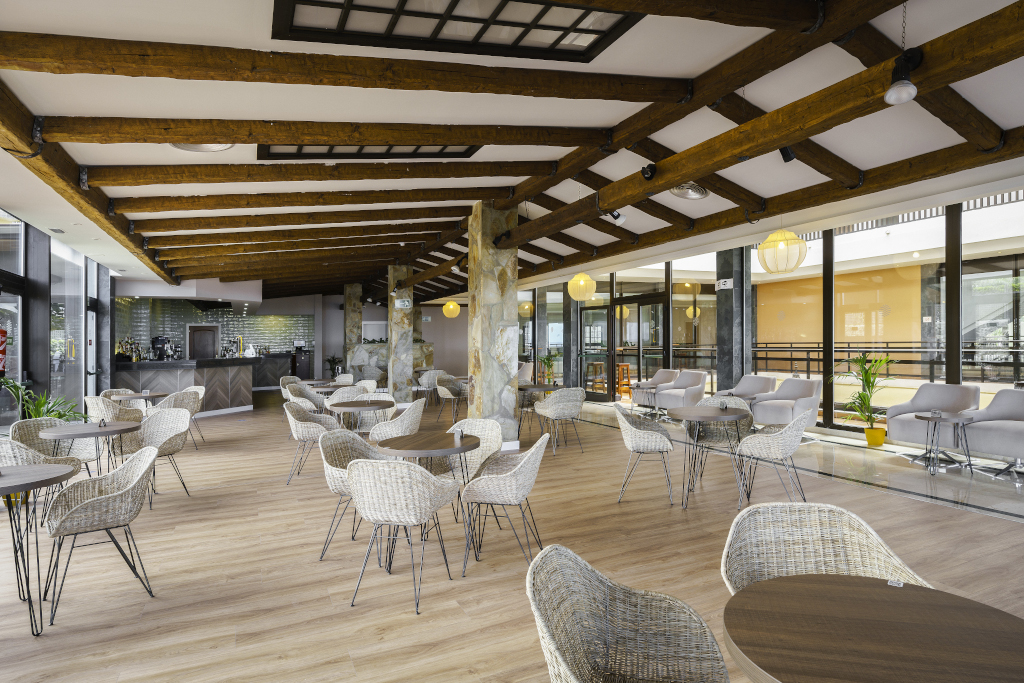 Offener Cafébereich mit Holzdeckenbalken in Teneriffa, leere Tische und Stühle.