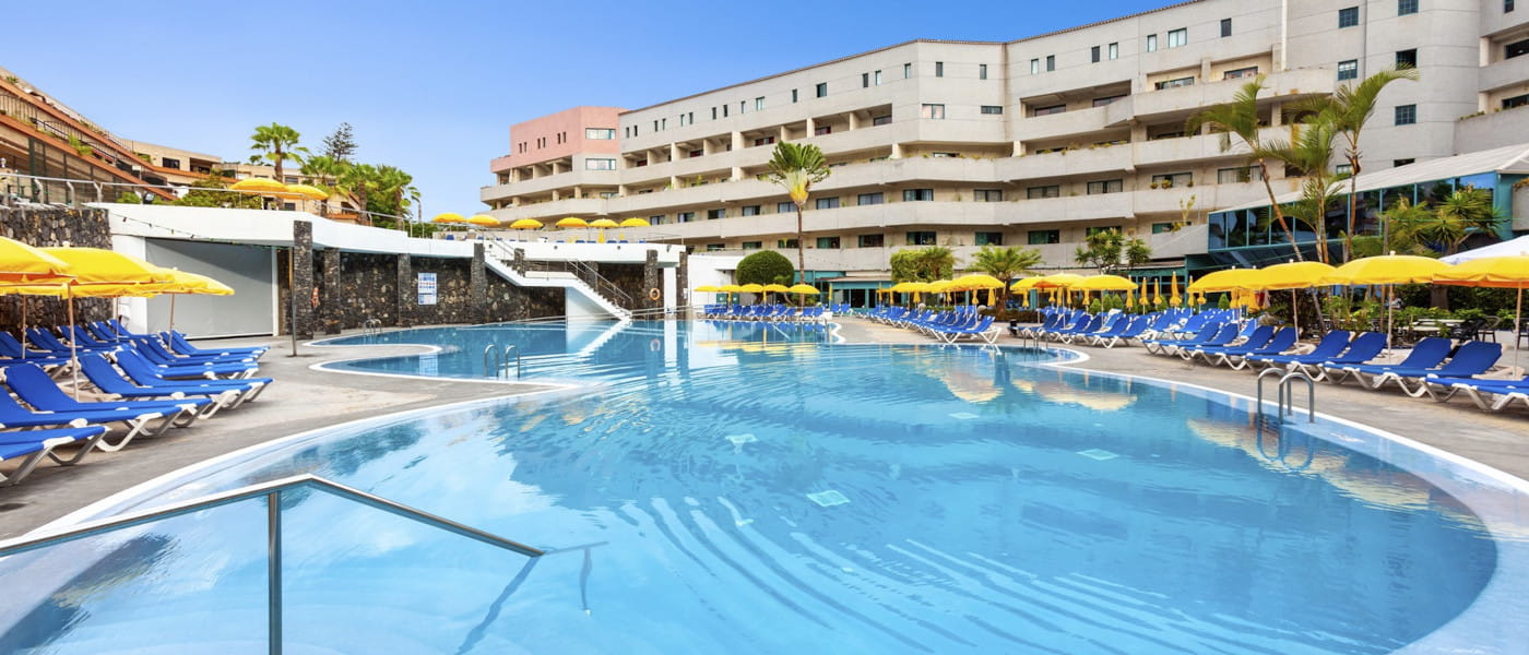 Poolbereich im Hotel in Puerto de la Cruz, Teneriffa, umgeben von Sonnenliegen.