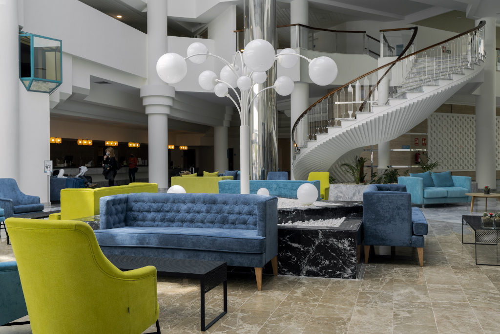 Elegante Lobby mit blauen und gelben Sesseln, Wendeltreppe in einem Hotel in Tenerife.