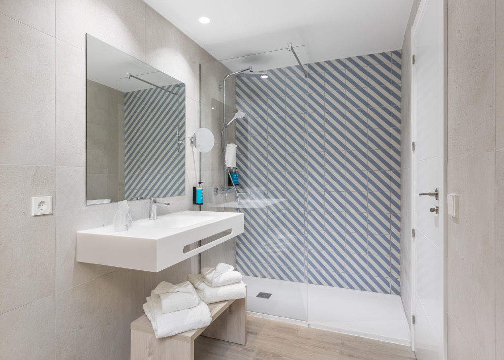 Modernes Badezimmer mit blau-weiß gestreiften Fliesen in Teneriffa.