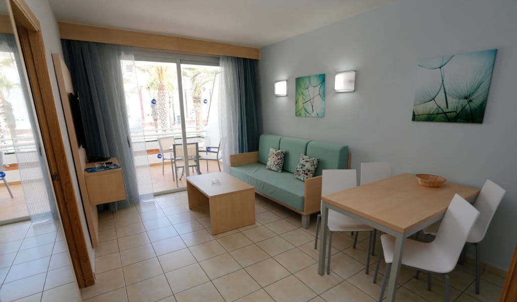 Wohnzimmer mit Sofa, Esstisch und Balkonblick in Playa de las Américas, Teneriffa.