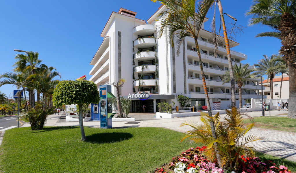 Mehrstöckiges Gebäude mit Balkon und Schild Andorra in Tenerife, umgeben von Palmen.