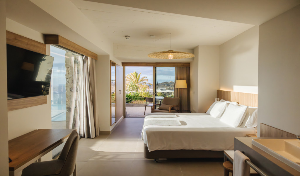 Modernes Hotelzimmer mit Doppelbett und Blick auf die Landschaft von Teneriffa.