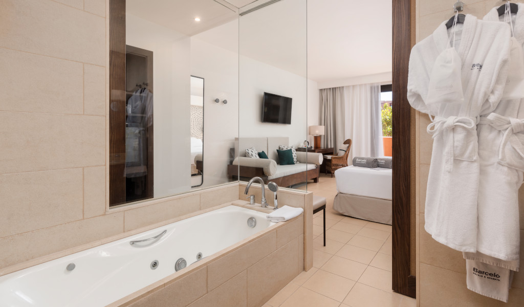 Badezimmer mit Badewanne und Blick auf das Schlafzimmer eines Hotels auf Teneriffa.