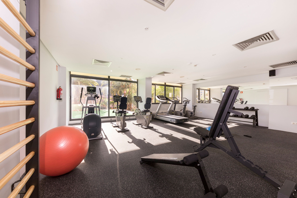 Fitnessraum mit Trainingsgeräten und rotem Gymnastikball in einem Hotel in Teneriffa.