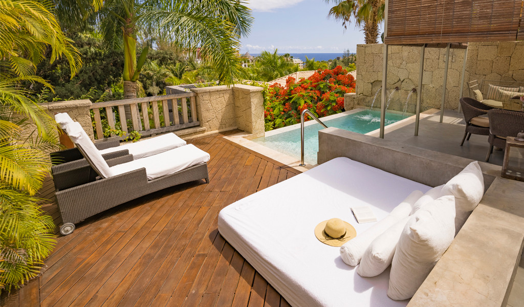Sonnendeck mit Poolblick, umgeben von Pflanzen in Puerto de la Cruz, Teneriffa.