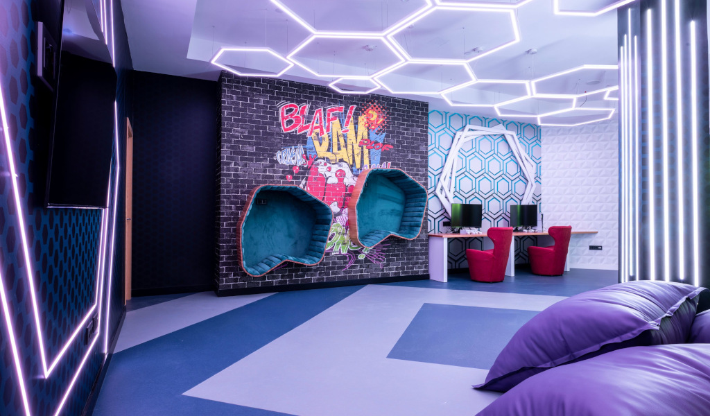 Innovativ beleuchteter Raum mit Graffiti-Wand und Computertischen in Tenerife.
