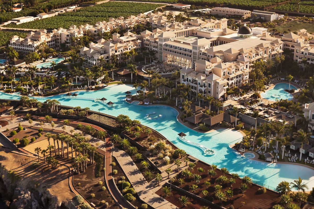 Luftaufnahme eines großen Resorts in Costa Adeje, Teneriffa, mit vielen Palmen und Pools.