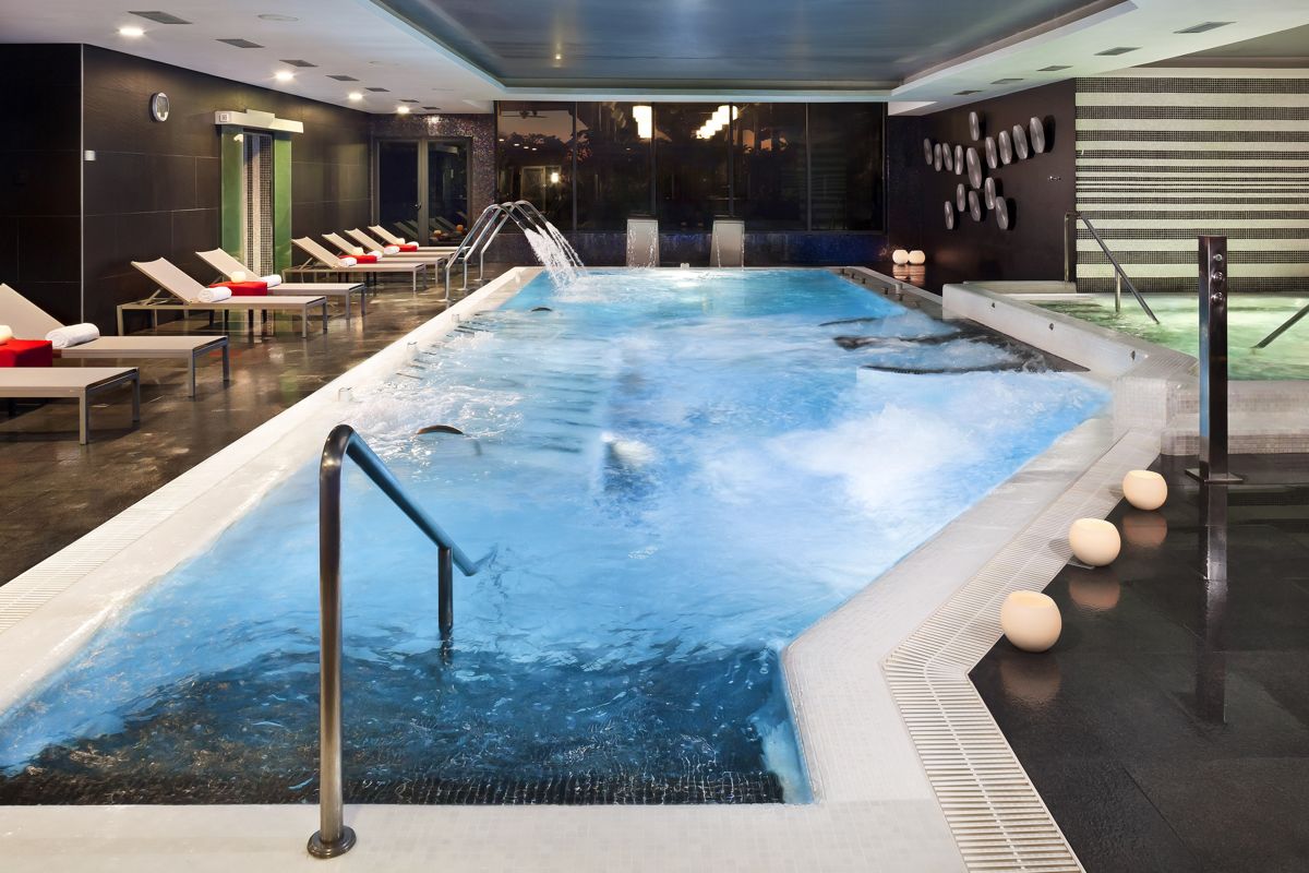 Innenpool mit Liegestühlen und Wasserjets im Spa von Tenerife.