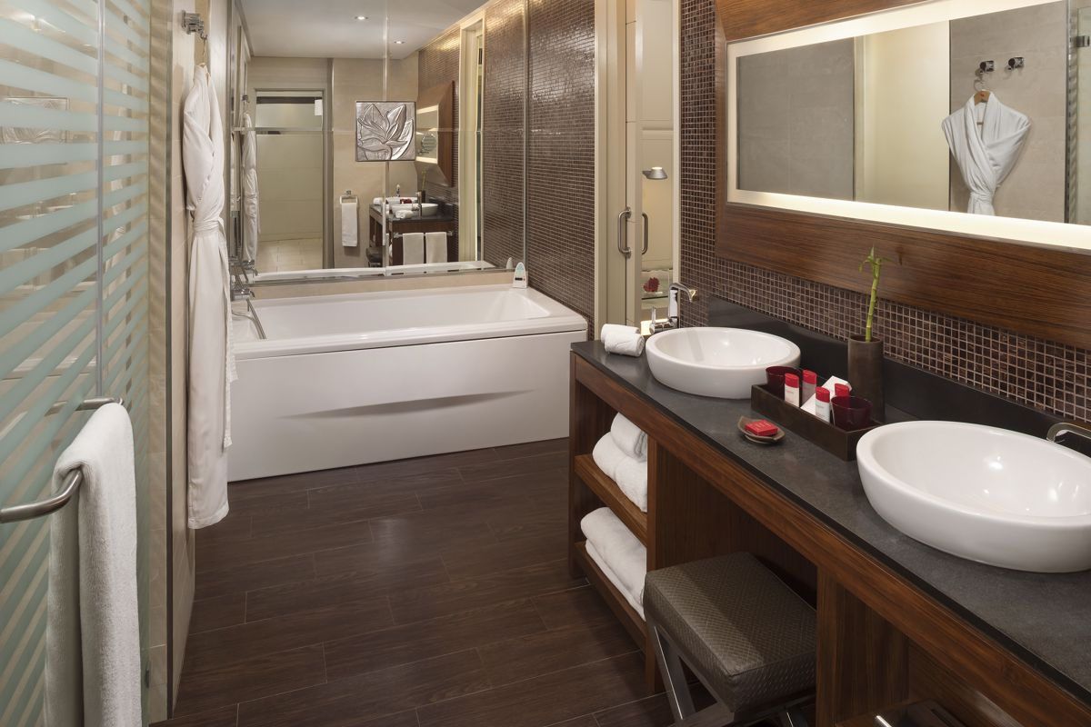 Ein elegantes Badezimmer im Hotel von Teneriffa mit Badewanne und zwei Waschbecken.