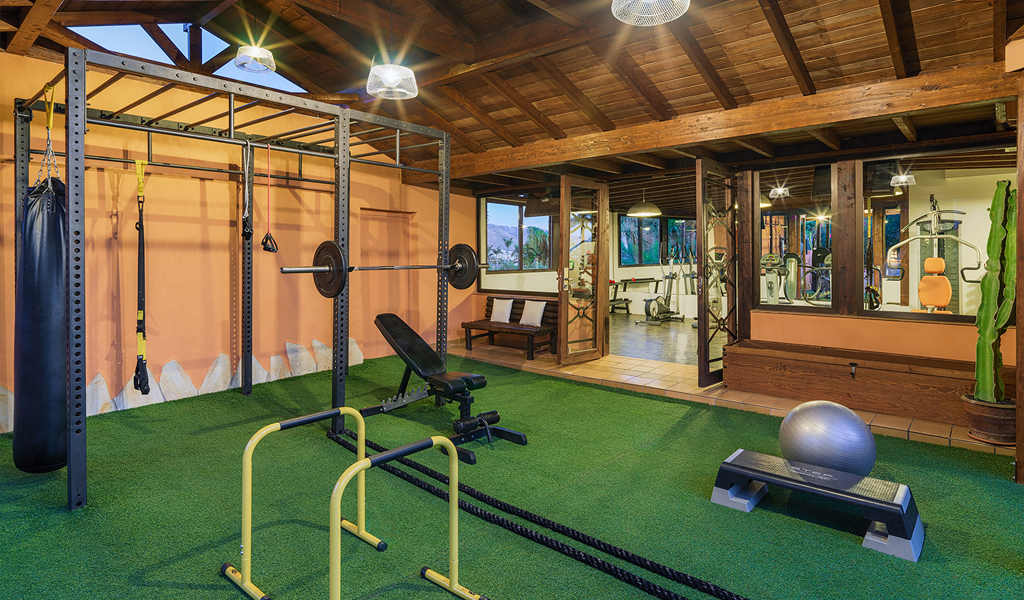 Fitnessraum in Teneriffa mit Hanteln, Boxsack, Fitnessball und Geräten.