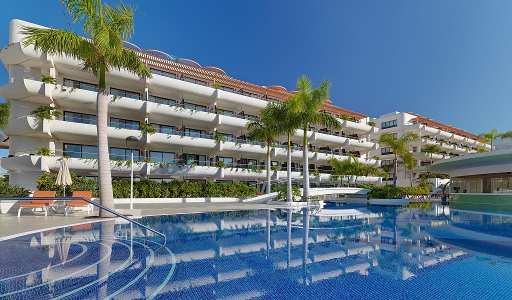 Moderne Hotelanlage mit Palmen und Pool in Costa Adeje, Teneriffa.