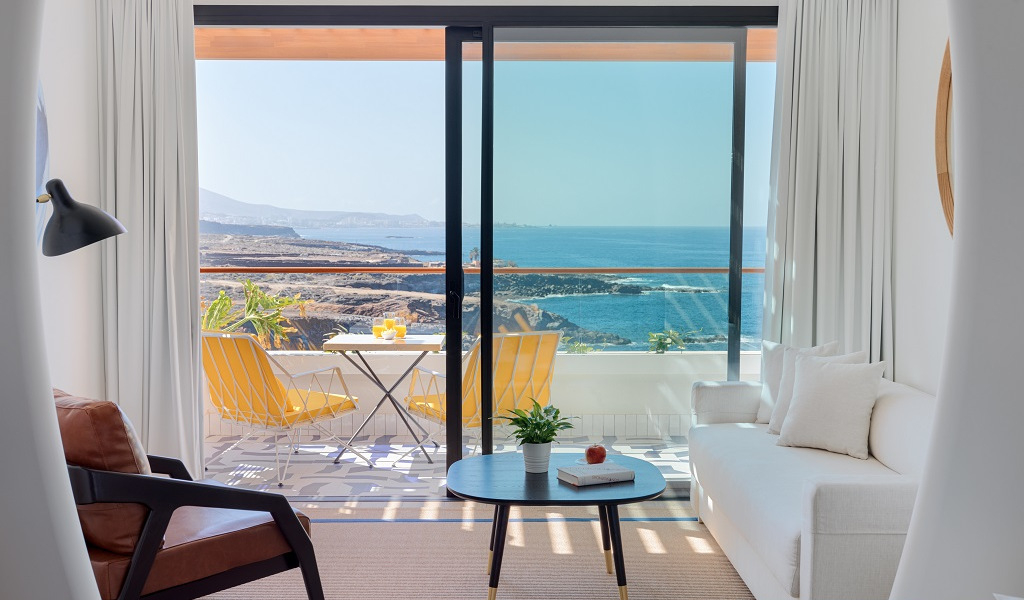 Wohnzimmer mit Balkonblick auf den Ozean in Teneriffa, Tisch mit Getränken.