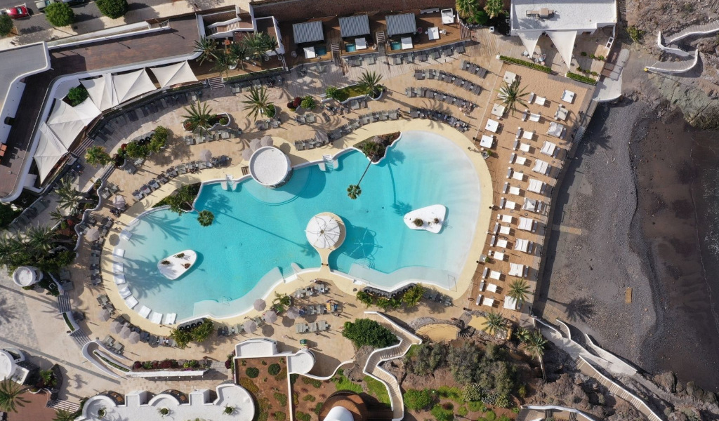 Luftaufnahme eines Pools mit Liegen am Strand in Costa Adeje, Teneriffa.