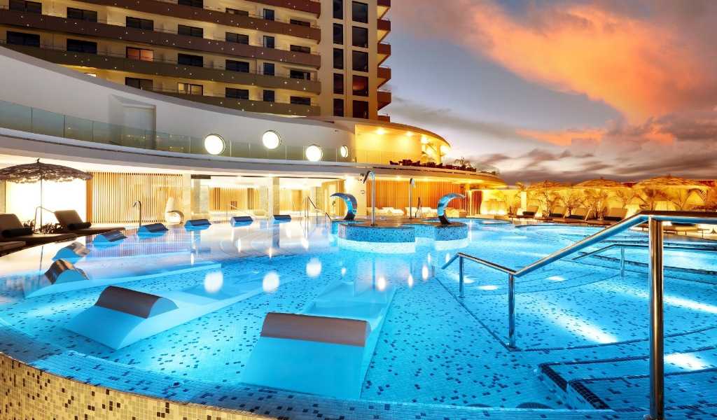 Beleuchteter Hotelpool bei Sonnenuntergang in Costa Adeje, Teneriffa.