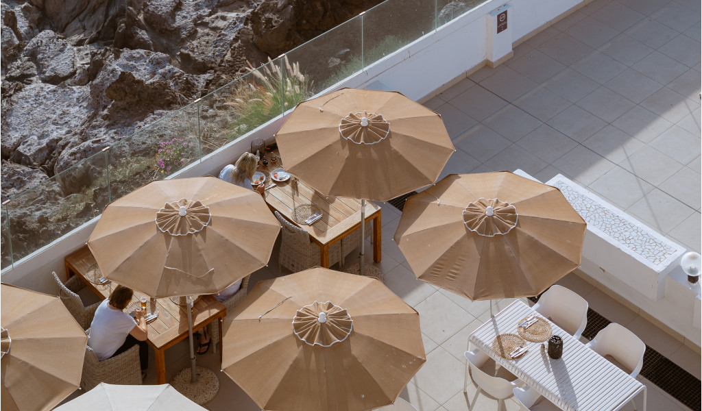 Restaurantterrasse mit braunen Sonnenschirmen in Garachico, Teneriffa.