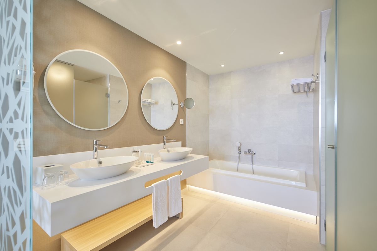 Modernes Badezimmer mit zwei Waschbecken, Badewanne und runden Spiegeln. Santa Cruz de Tenerife.