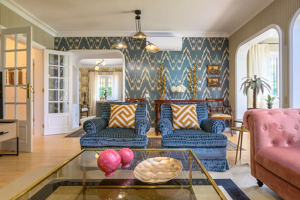Wohnzimmer mit blauen Sofas, Kissen und Musterwand in Tenerife.