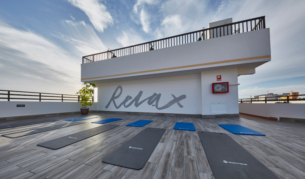 Yogamatten auf einer Terrasse mit Relax Wandbild im Hotel in Tenerife.