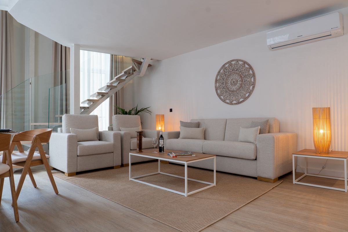 Modernes Wohnzimmer mit Sofa, Sesseln und Tisch in einem Ferienhaus in Tenerife.