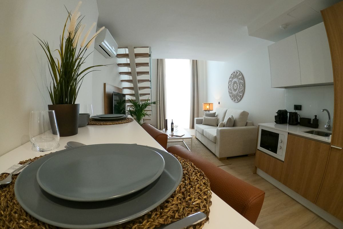 Wohnzimmer einer modernen Ferienwohnung in Teneriffa mit Küche und Essbereich.