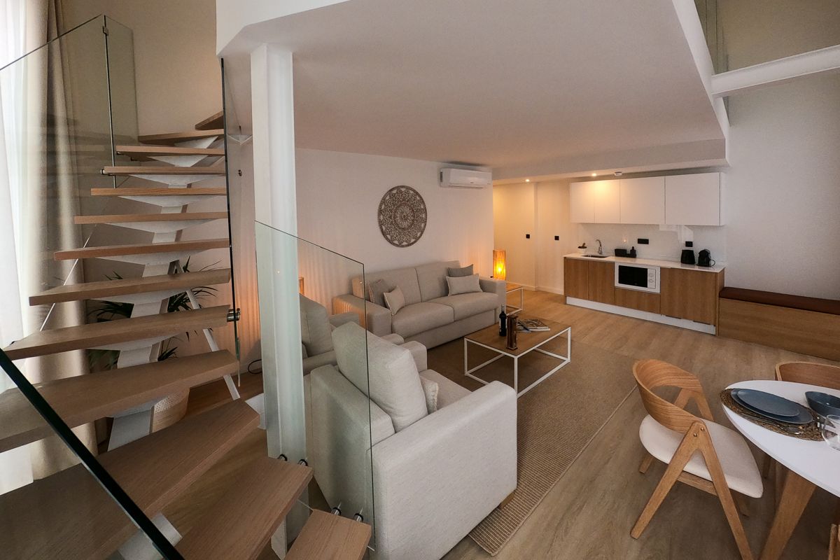 Moderne Wohnzimmer und Küche mit Treppe in einem Apartment in Tenerife.