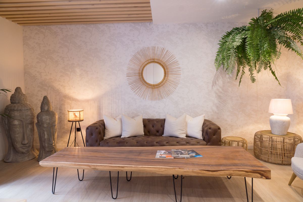 Wohnzimmer mit Sofa, Kaffeetisch, Buddha-Statuen und Pflanzen in Hotel Tenerife.