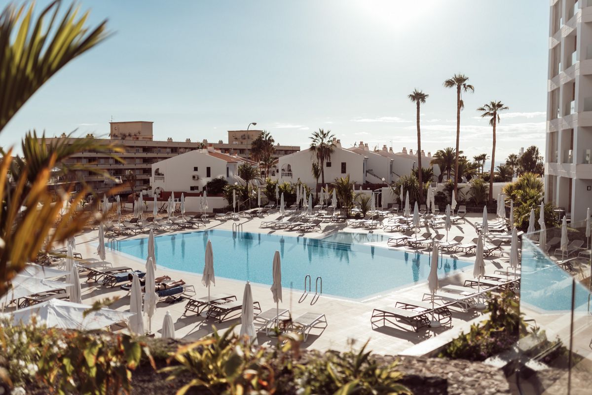 Poolbereich mit Liegen und Sonnenschirmen in Playa de las Américas, Teneriffa.