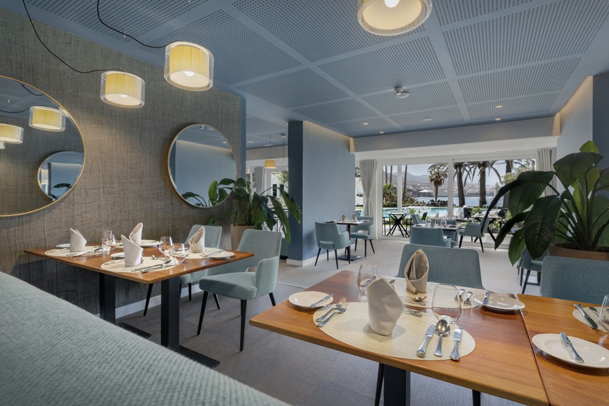 Elegantes Restaurant-Interieur mit gedeckten Tischen und Blick auf den Pool in Tenerife.