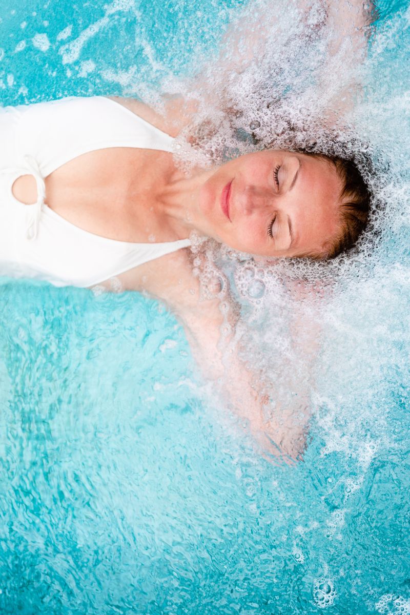 Frau im weißen Badeanzug im blauen Wasser in Puerto de la Cruz.
